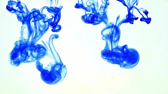 Blaue Tinte fällt in Wasser und vermischt sich in Strudeln und Wirbeln mit dem Wasser
