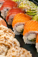 Close-up of a sushi assortment with caviar, philadelphia with salmon, and mango. Grill roll, tuna roll, avocado roll. Sushi delivery, photo for the menu