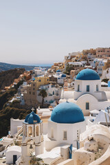 Beautiful Oia, Greece, with its iconic blue-domed churches overlooking the stunning caldera, a perfect blend of whitewashed buildings and breathtaking views.