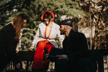 Obraz premium A vibrant group of young entrepreneurs engage in a creative brainstorming session outside amidst the buzz of city life, discussing strategies for success.