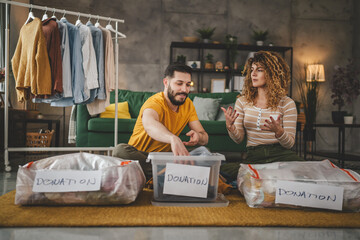 couple stand at home choose clothes for donation sorting wardrobe