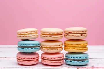 Colorful French macarons on a white table with a pink background a minimal dessert concept