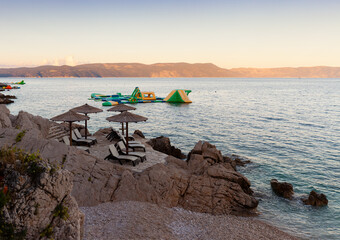 Straw beach umbrellas on the beach of Rabac, Croatia - 737529589