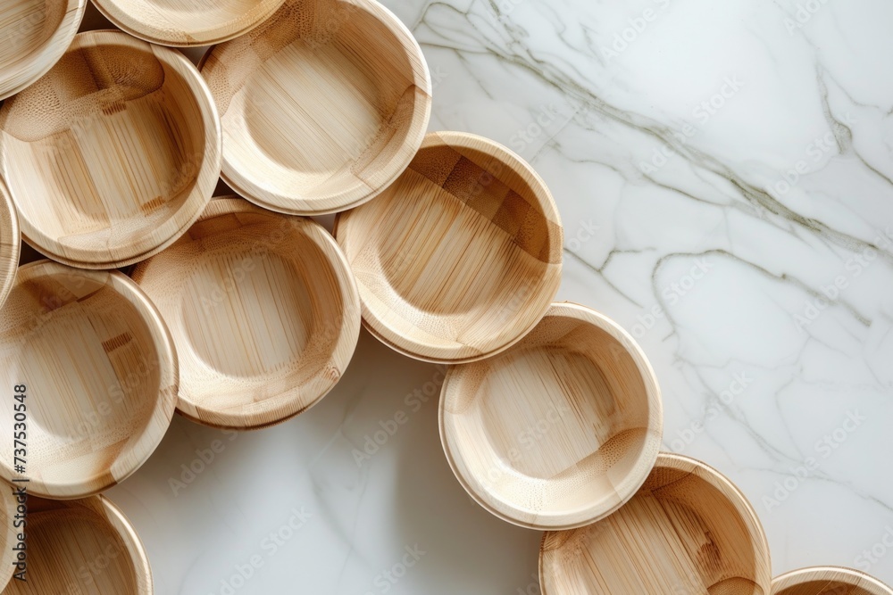 Poster a stack of wooden bowls arranged neatly on a sleek marble counter. perfect for adding a touch of rus