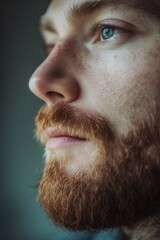A close up photograph of a man with a beard. This image can be used to represent masculinity, fashion, or grooming