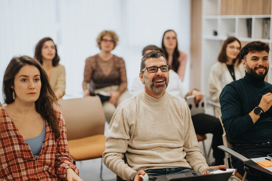 Business group of focused attendees participating in an educational workshop, showing attentiveness and interest.