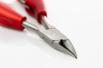 Close up of cuticle clippers and trimmers for nails with bright red handles on white background