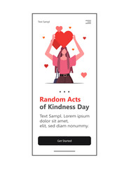 A modern young woman holds a red heart above her head to encourage acts of kindness. Random Acts of Kindness Day is celebrated on February 17th. Web design and mobile template.
