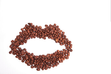 Coffee beans on a white background in the shape of lips. Fragrant, roasted Arabica beans. Copy space
