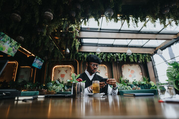 Focused young entrepreneur using smart phone in an eclectic, plant-filled city cafe. Modern remote work lifestyle in an urban environment.