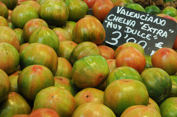 Pile of two-tone tomatoes (Solanum lycopersicum) in a Spanish market stall. Selective focus 