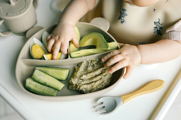 first blw baby food, little baby eating organic vegetables with BLW method. Infant eating healthy...