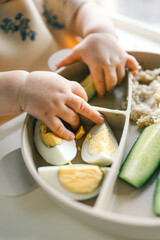 first blw baby food, little baby eating organic vegetables with BLW method. Infant eating healthy...