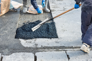 道路工事　アスファルトの舗装復旧工事　常温合材の敷均し