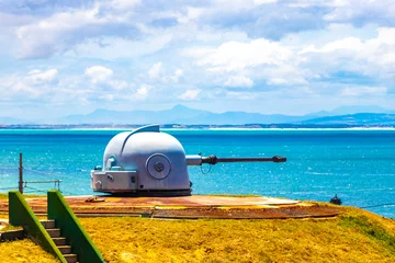 Gordijnen Sentry gun cannon blue sea Beach Cape Town South Africa. © arkadijschell