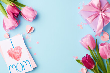 Heartfelt homage: handcrafted love for Mother's Day. Top view shot of pink tulips, "I Love Mom" card, heart-shaped decor, lavender gift box on pastel blue background with space for heartfelt messages
