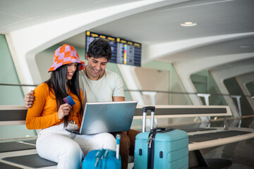 couple at the airport with laptop and credit card