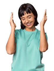 Young Hispanic woman with short black hair in studio joyful laughing a lot. Happiness concept.