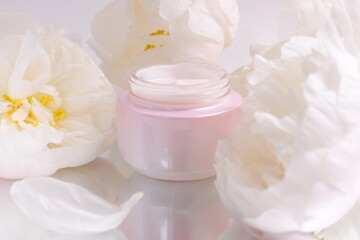 Fototapeta na wymiar Cream cosmetic jar mock up with flowers on background, skin care therapy