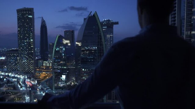 Young Man Succeed In High Rise Apartment Looking at Urban Buildings