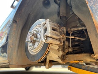 Fototapeta premium An electric vehicle inspection involves checking brake pads and disc brakes for malfunctions, ensuring safe and efficient vehicle operation