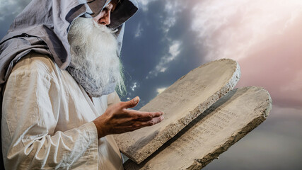 The Old Testament biblical prophet Moses holds the tablets with the ten  commandments - 737594998