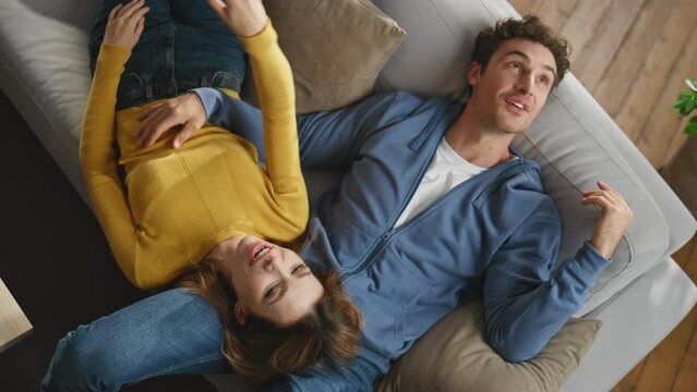 Happy pair enjoying weekend talking at couch closeup. Lovers imagining future