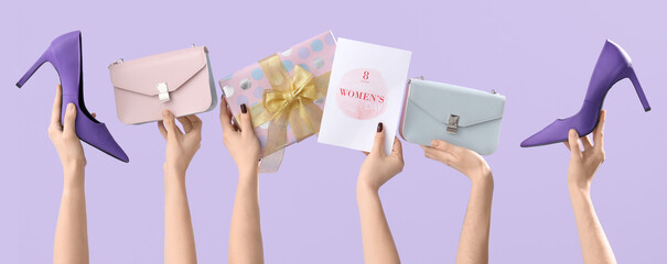 Female hands with greeting card, handbags and high heel shoes on lilac background. Shopping for...