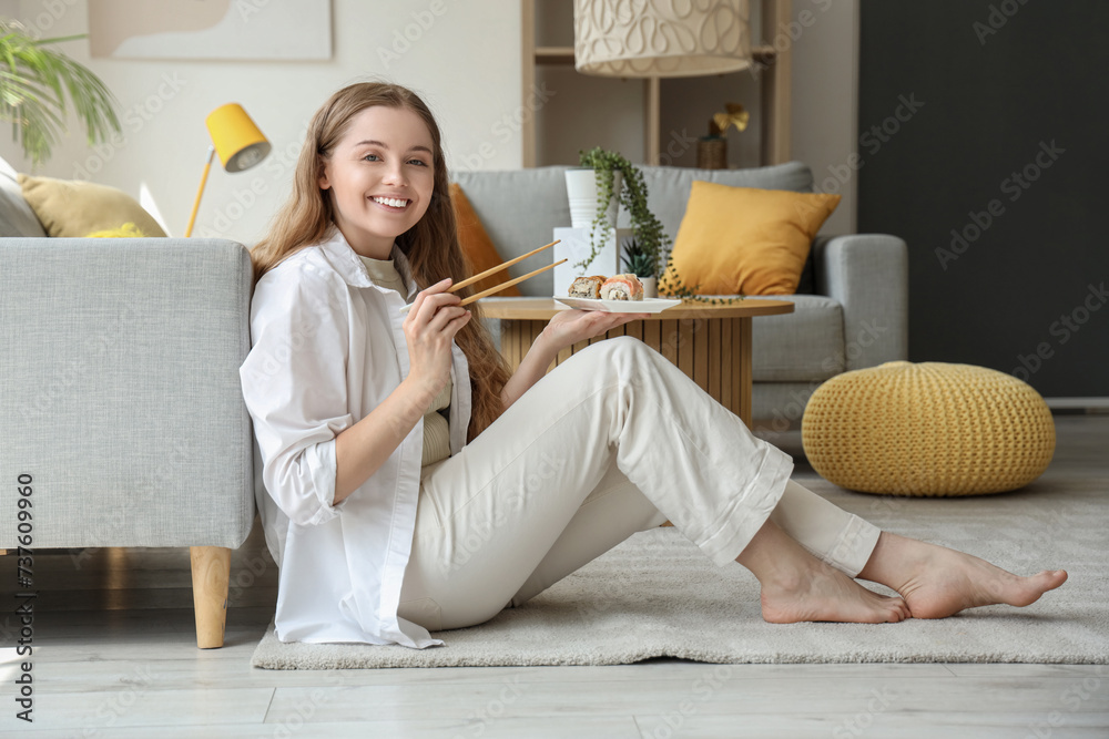 Canvas Prints Happy young woman eating sushi in living room