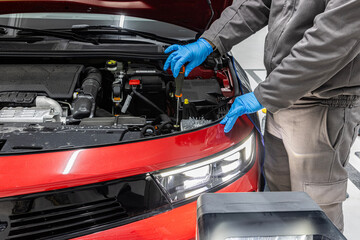 Headlight adjustment of the car in the car service. car repair shop worker checks and adjusts the headlights of a car's lighting system.