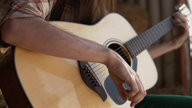 Musician with long straight hair plays guitar