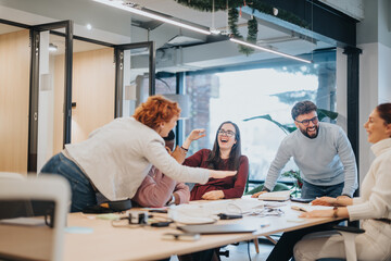 Obraz premium Businesswoman and colleagues celebrating successful project completion in office.