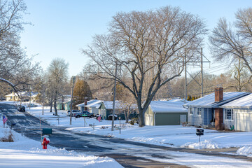 Snowy Minnesota suburban neighborhood street, late afternoon sun.