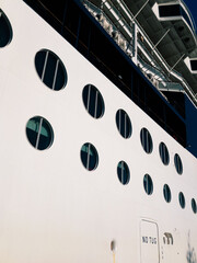 Side of a navy and white ship with portholes