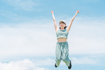 Fototapeta na wymiar ジャンプ・有酸素運動・スポーツ・運動・筋トレするスポーツウェアを着た日本人女性 