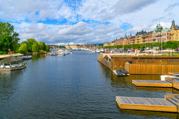 Naklejka premium Boats line the docks and marinas along the Strandvägskajen promenade, a picturesque waterfront park and open space in the historic center of Stockholm, Sweden.