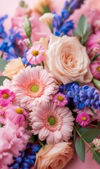 Soft pink and blue spring flowers with a plain blurred pink background. 