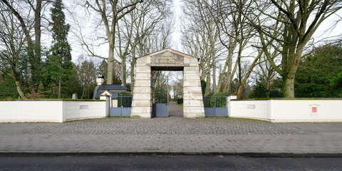 Fototapeta premium old main entrance with imposing archway of the historic Melaten cemetery on aachener strasse in cologne