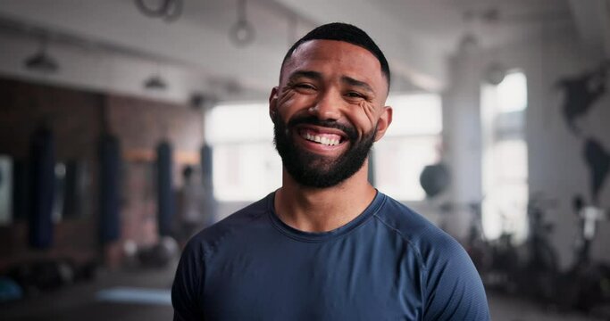 Fitness, face and happy man at a gym for morning workout, exercise or body challenge for wellness. Training, portrait and male personal trainer at a sports center for workout, goals or club coaching