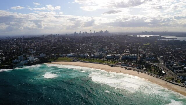 Aerial Panning Beautiful View Of Modern Suburb At Bondi Beach, Drone Flying Over Wavy Sea On Sunny Day - Sydney, Australia