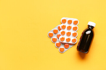 Pills for sore throat with cough syrup on orange background