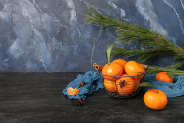 Basket of sweet mandarins with cinnamon and star anise on black table