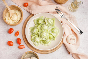 Plate of tasty ravioli with cheese on white background