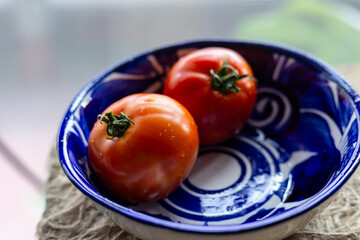 Jitomates bola maduro dentro de plato artesanal mexicano