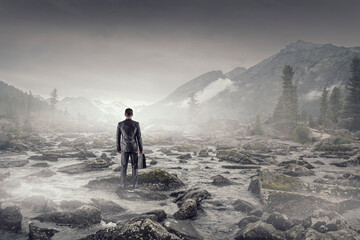 Young businessman standing and rock mountain