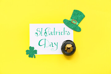 Pot with golden coins, festive card and decor on yellow background. St. Patrick's Day celebration