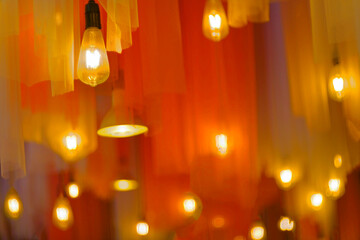 Hanging orange retro light bulb with yellow orange curtain 