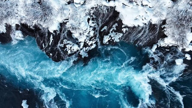 Pure turquoise water, glacial river with huge current, Waterfall in Iceland, Frozen waterfall in winter, magical winter location of snow and ice, Popular tourist attraction
