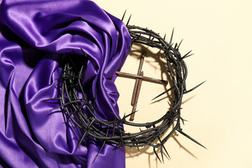 Crown of thorns with purple fabric and nails on beige background - obrazy, fototapety, plakaty