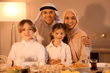 Happy Muslim family having dinner at home in evening. Ramadan celebration